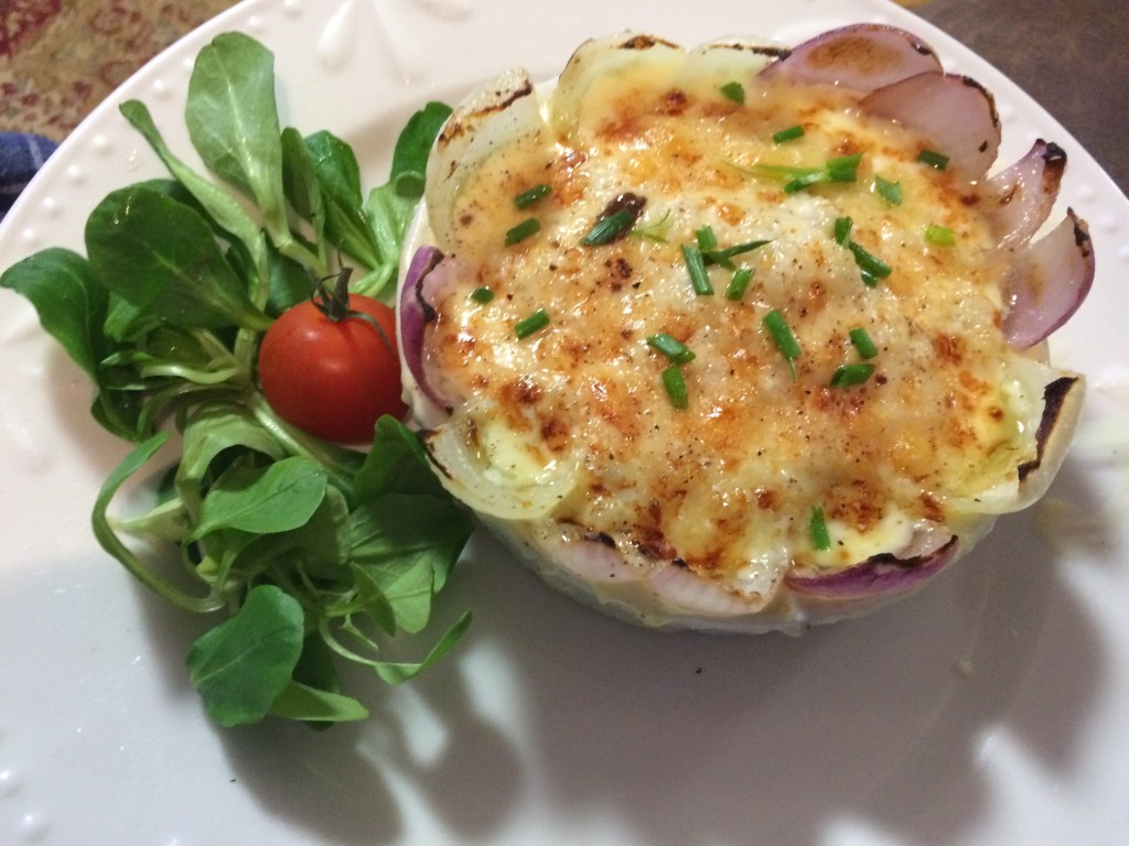 Lambs leaf lettuce with a dish of homemade gluten free German spaetzle topped with cheese (Kase) and chives. Sweet red onion surround the dish. Made by Charisa (18).